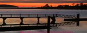 sunset over a dock with a sloping ramp from shore