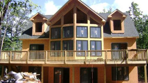 New  home under construction Glass fronted with small windowed dormers either side of main prowfront. This style typical in the Bala and Muskoka area where they overlook the lakes, is just one of many new home styles being built. What they all might have to the owners benefit is an on going construction inspection, or, Phase inspection to ensure building products and applications follow manufactures recommendations, and to inspect on a regular basis the construction so as to avoid multi trade rework when one small thing gets missed or done wrong.