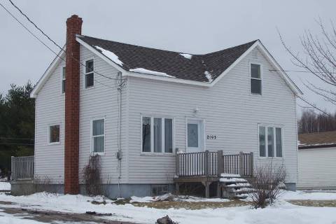 This photo of an older Muskoka  home buil in the t50s with wood cladding and a  brick chimney 2 stories tall  likely has several things to be found during a home tnspection. From first glance handrails are missing on front stairs and that is just a begining.